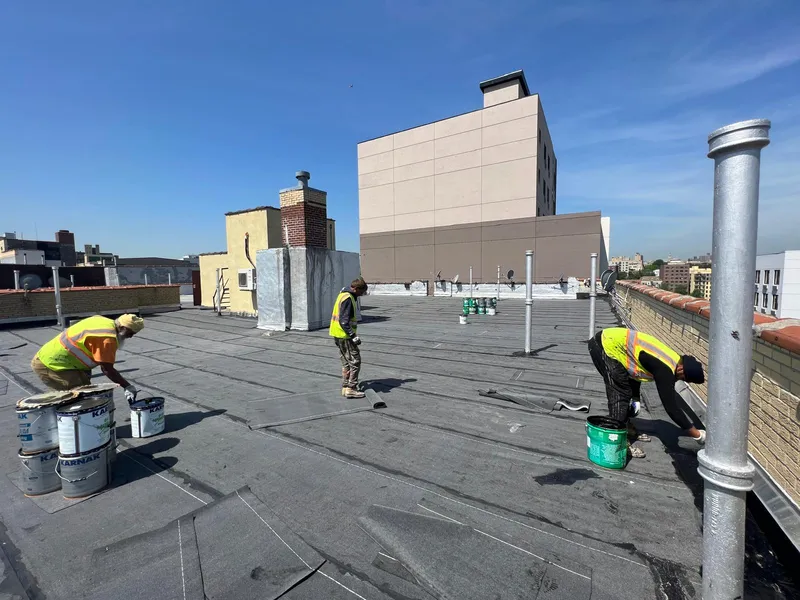 Rooftop waterproofing work on a Queens commercial building